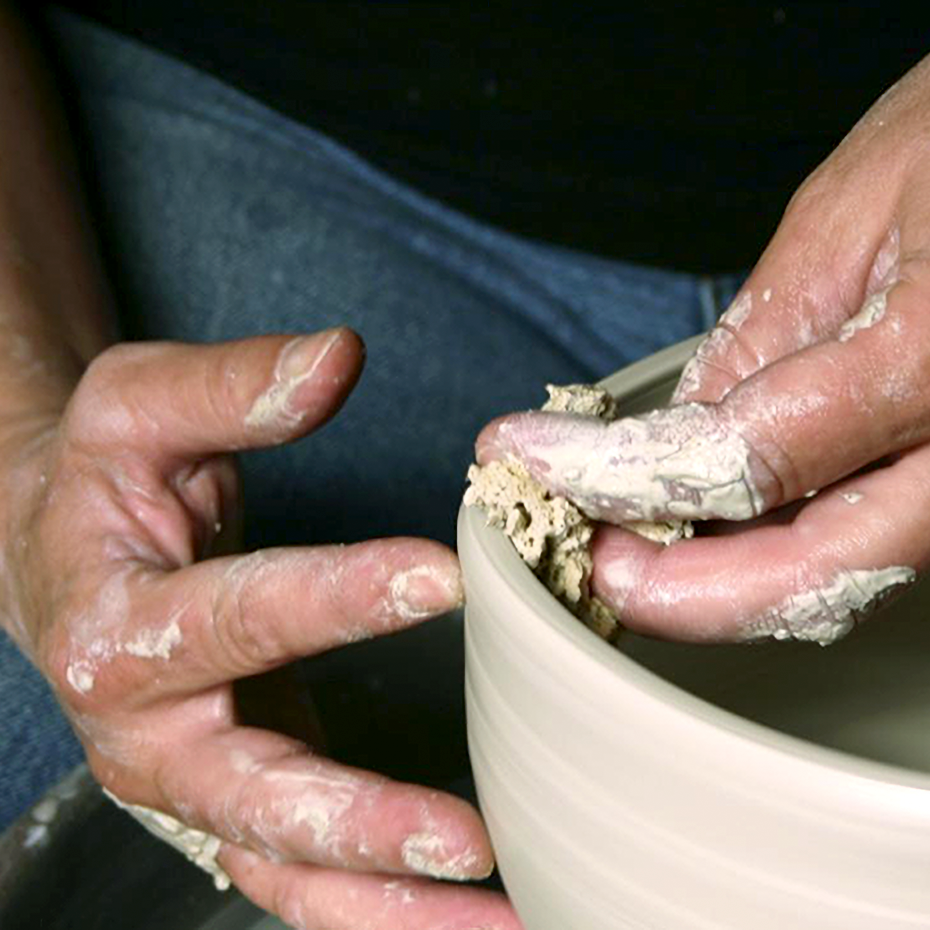 person throwing ceramics on wheel