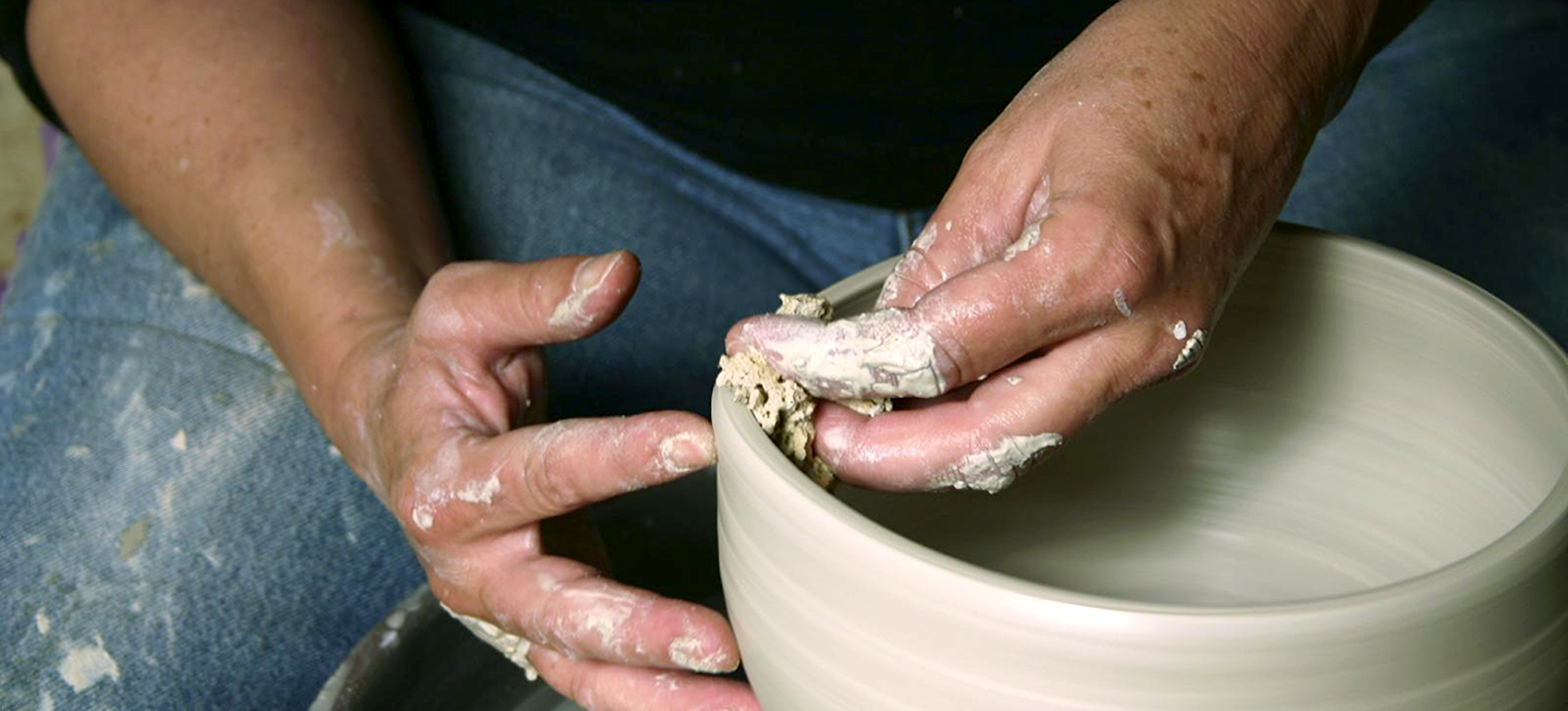 person throwing ceramics on wheel